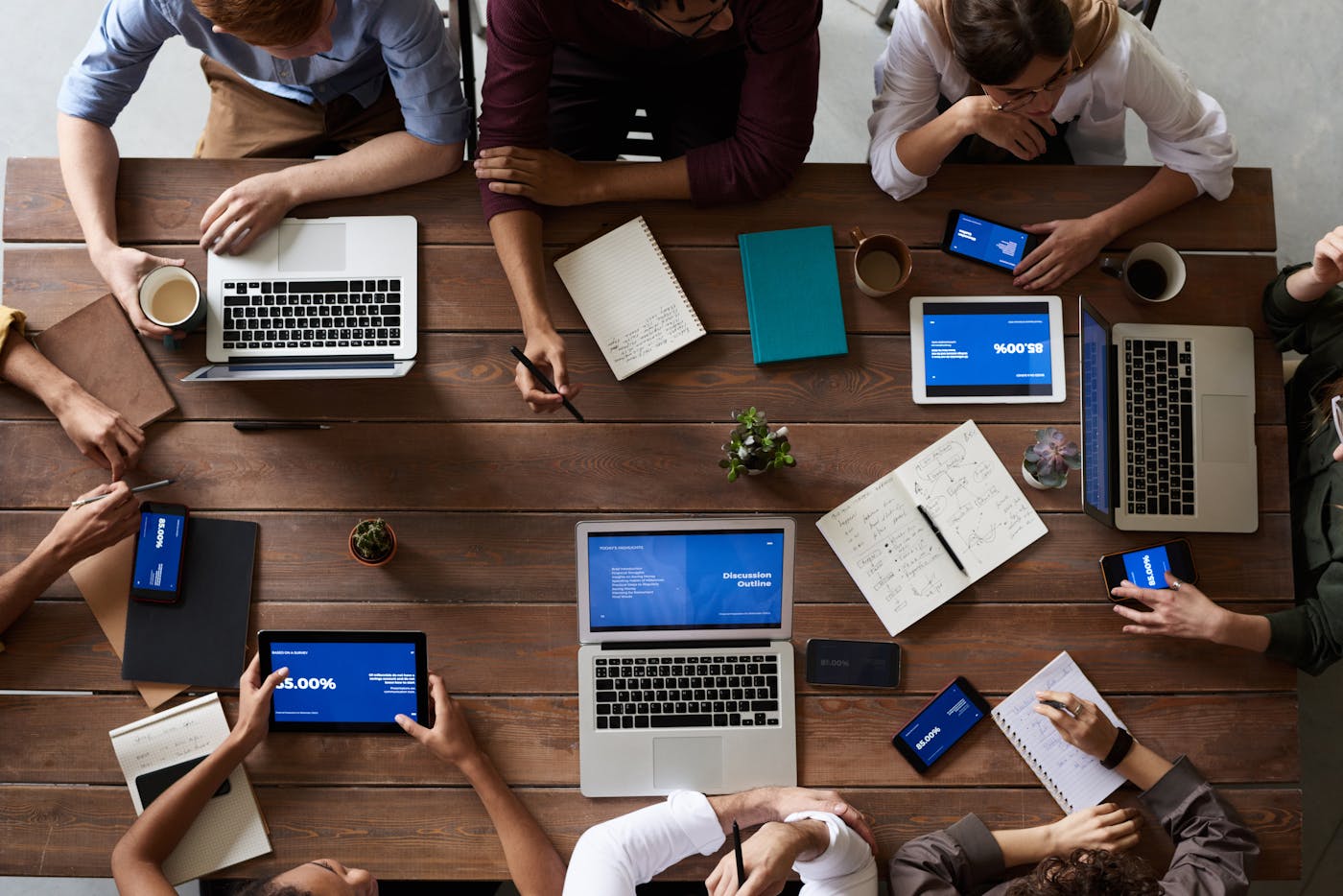 Colleagues collaborating at a table with laptops